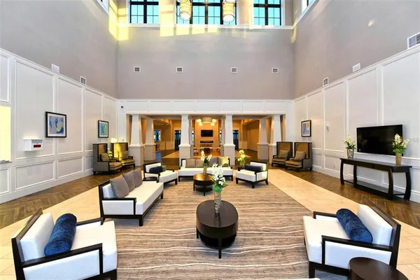 a living room with furniture a flat screen tv and a large window