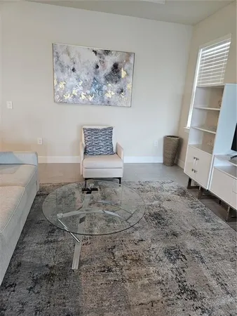 a living room with furniture a large window and a flat screen tv