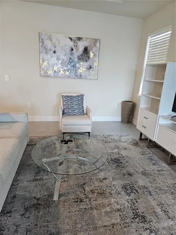 a living room with furniture a large window and a flat screen tv