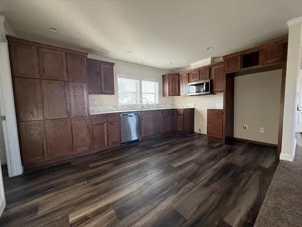a kitchen with granite countertop a refrigerator and a stove top oven