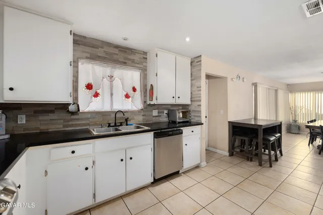 a kitchen with granite countertop a sink and cabinets