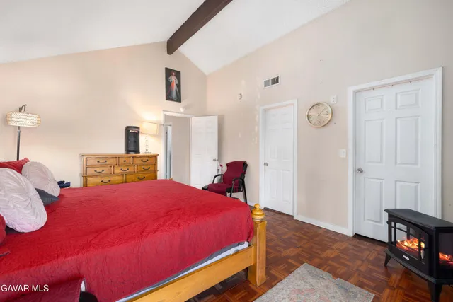 a bedroom with a bed and a lamp with the wooden floor