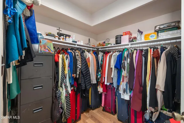a view of walk in closet with clothes and shoes
