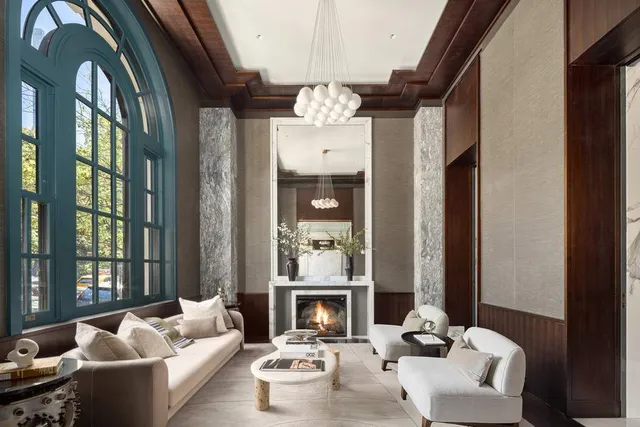 a living room with furniture fireplace and large windows