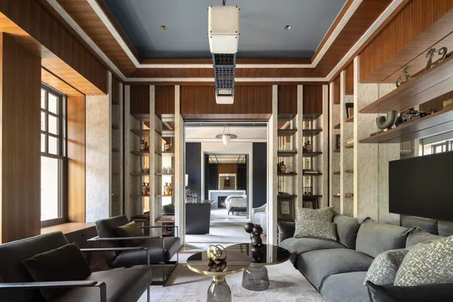 a living room with furniture fireplace and large windows