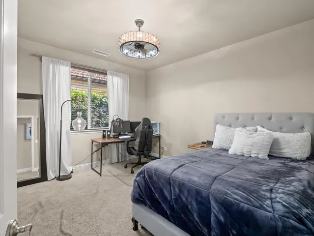 a spacious bedroom with a bed and a flat screen tv