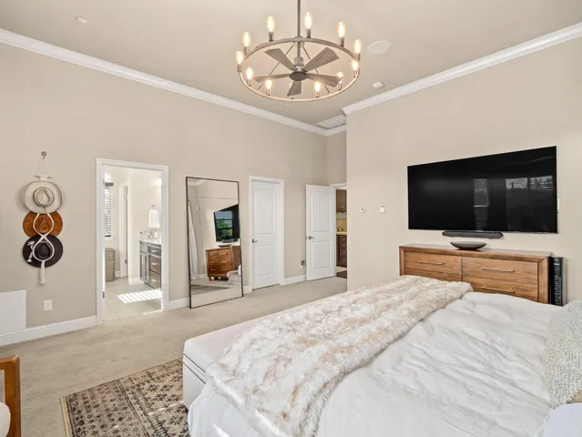 a bedroom with a large bed and a chandelier