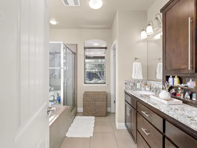 a bathroom with a granite countertop sink and a large mirror