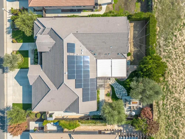 a dining room with wooden floor a chandelier a glass table and chairs