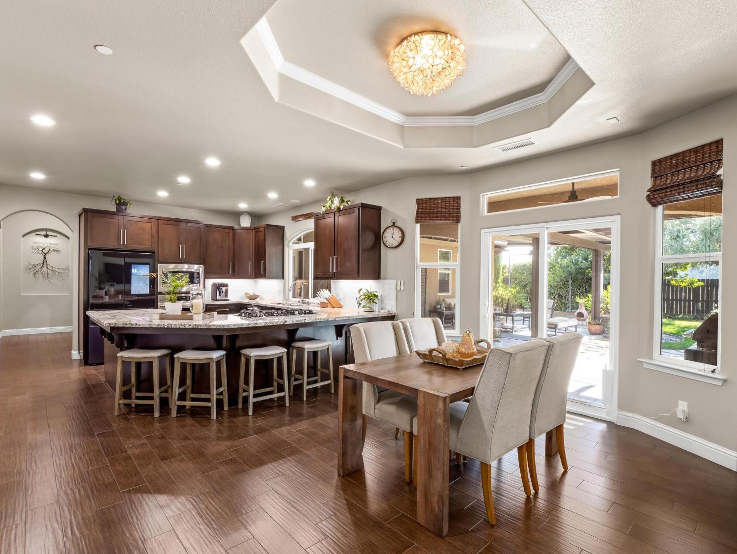 2750 Muncie Avenue Clovis, CA 93619 - Photo 34 of 51 a dining room with wooden floor a chandelier a glass table and chairs