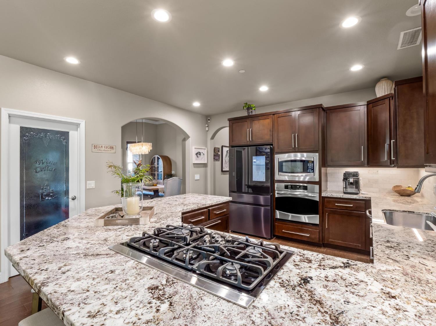 2750 Muncie Avenue Clovis, CA 93619 - Photo 35 of 51 a kitchen with stainless steel appliances kitchen island granite countertop a stove and refrigerator