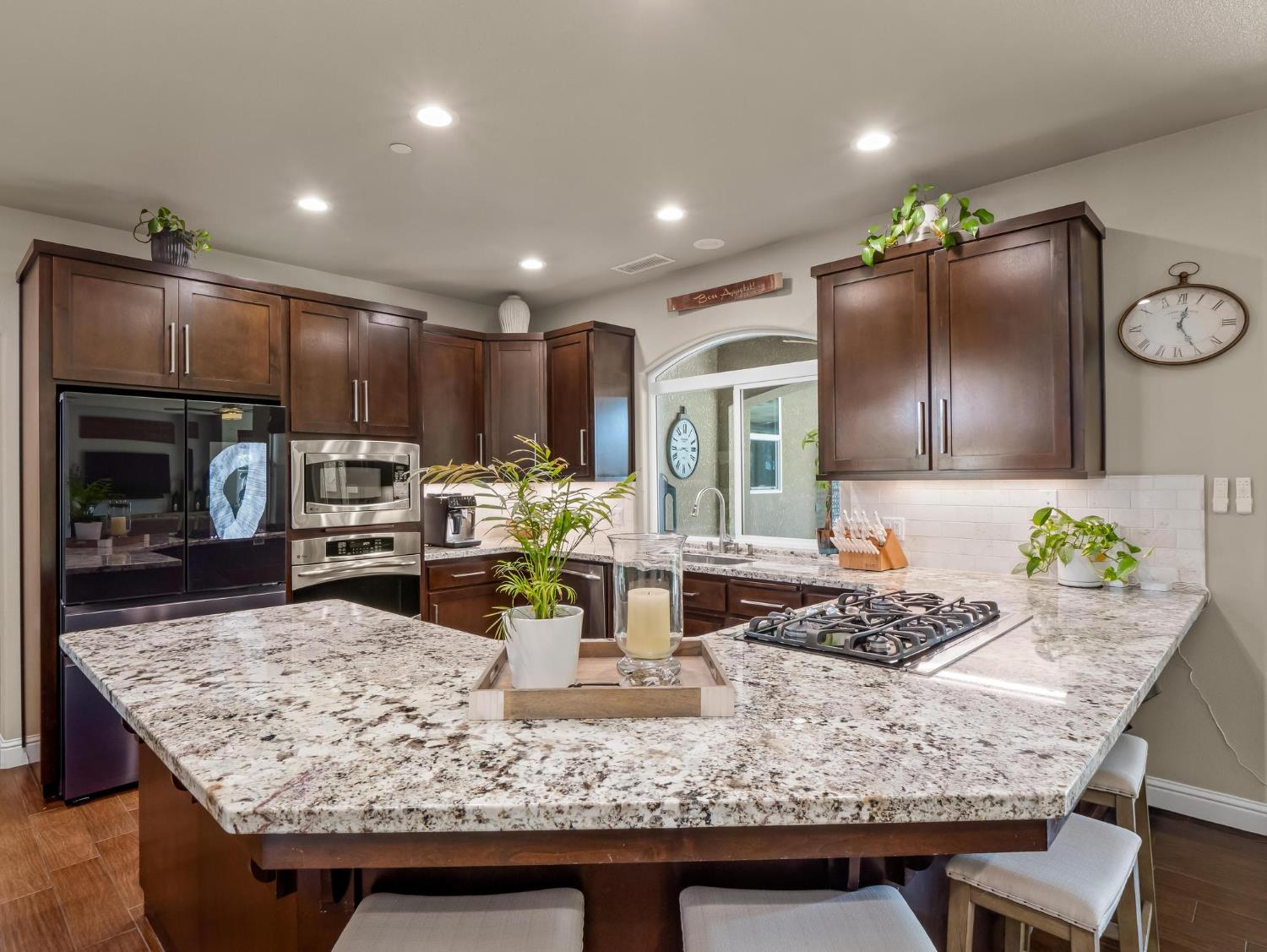 2750 Muncie Avenue Clovis, CA 93619 - Photo 36 of 51 a kitchen with kitchen island granite countertop wooden cabinets and a refrigerator