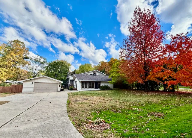 a front view of a house with a garden and trees