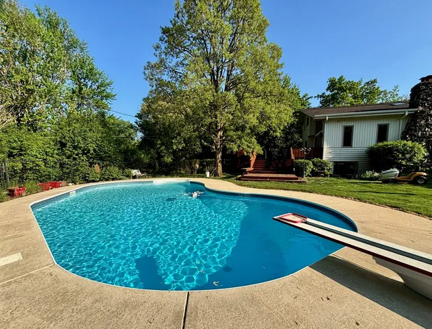 a view of a swimming pool with a yard and outdoor seating