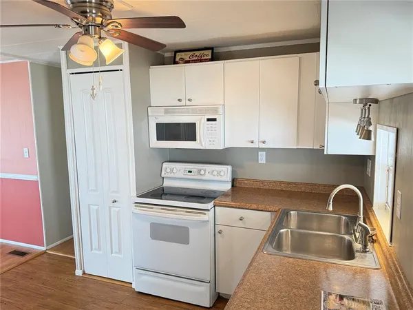 a kitchen with appliances a sink and cabinets