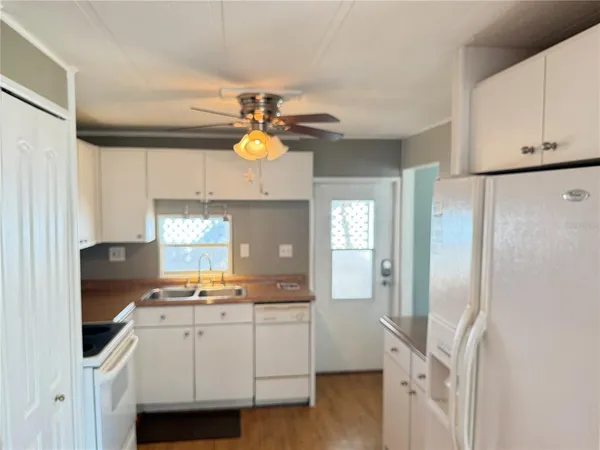 a kitchen with a refrigerator and white cabinets