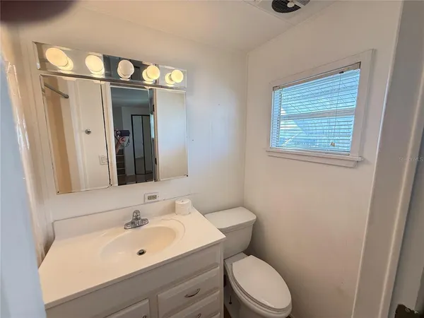 a bathroom with a sink vanity mirror and toilet