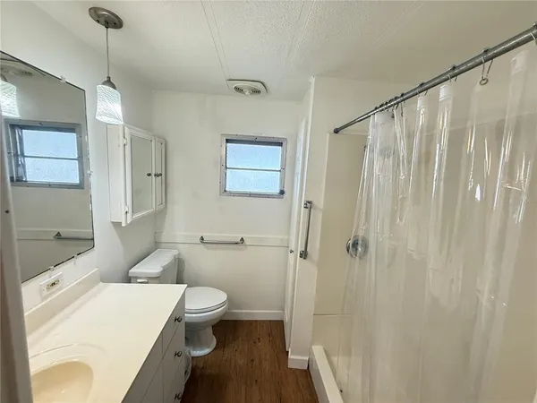 a bathroom with a sink a toilet and shower