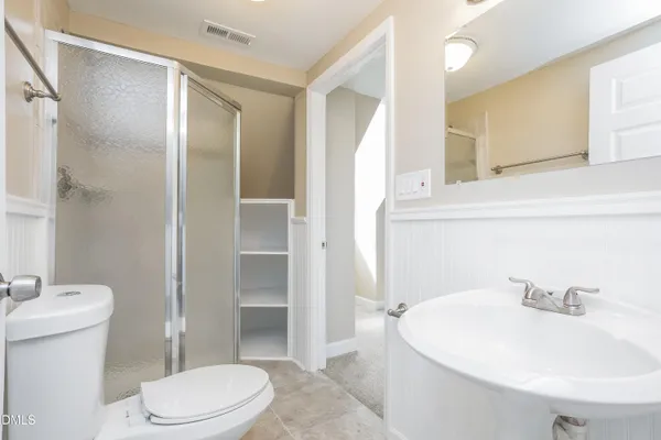 a bathroom with a sink a toilet and shower