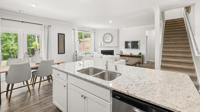 a kitchen with granite countertop a sink and white cabinets