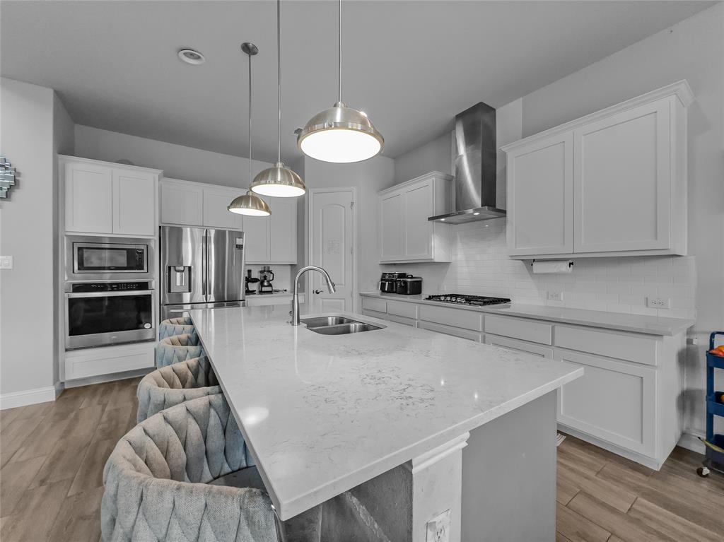116 Chaco Drive Forney, TX 75126 - Photo 9 of 27 a kitchen with stainless steel appliances granite countertop a sink a stove and a wooden floors