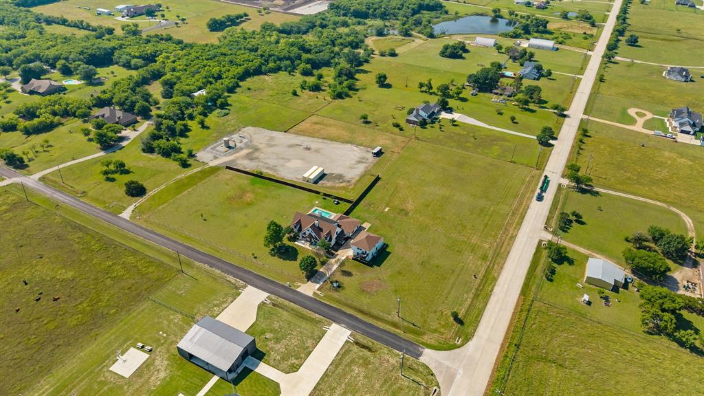 12240 Wellington Road Ponder, TX 76259 - Photo 39 of 40 Expansive rural property featuring a large residence with a swimming pool, multiple outbuildings, and an extensive land area with mature trees and open fields