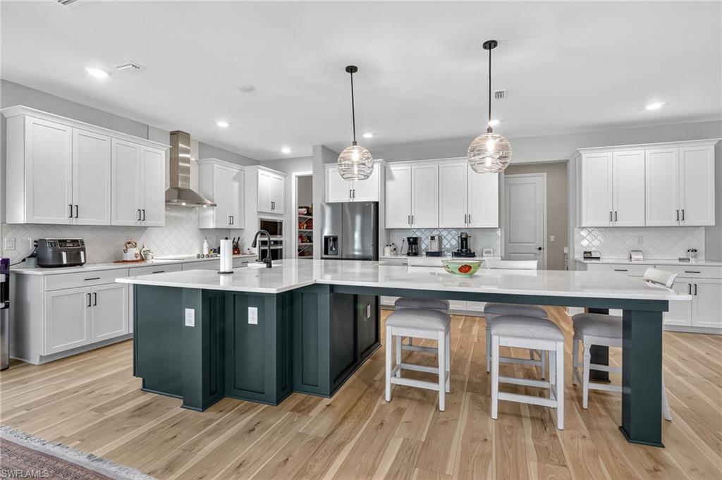 2082 Grove Drive Naples, FL 34120 - Photo 11 of 50 a kitchen with kitchen island granite countertop a sink a counter space appliances and cabinets