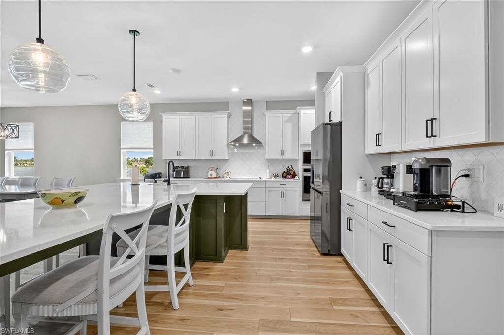2082 Grove Drive Naples, FL 34120 - Photo 16 of 50 a kitchen with stainless steel appliances granite countertop a stove top oven a refrigerator a sink and chairs