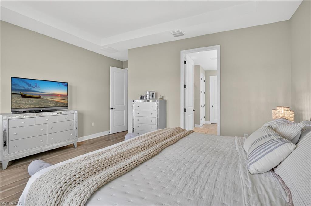 2082 Grove Drive Naples, FL 34120 - Photo 19 of 50 a bedroom with a bed and a flat screen tv