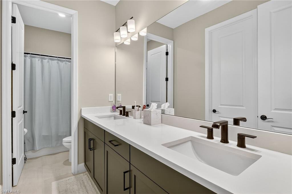 2082 Grove Drive Naples, FL 34120 - Photo 28 of 50 a bathroom with double vanity sinks and a mirror