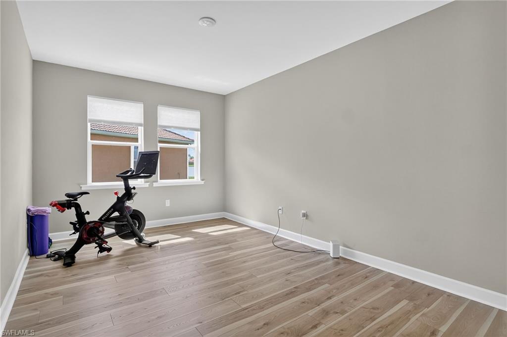 2082 Grove Drive Naples, FL 34120 - Photo 29 of 50 a view of room with wooden floor and gym equipment