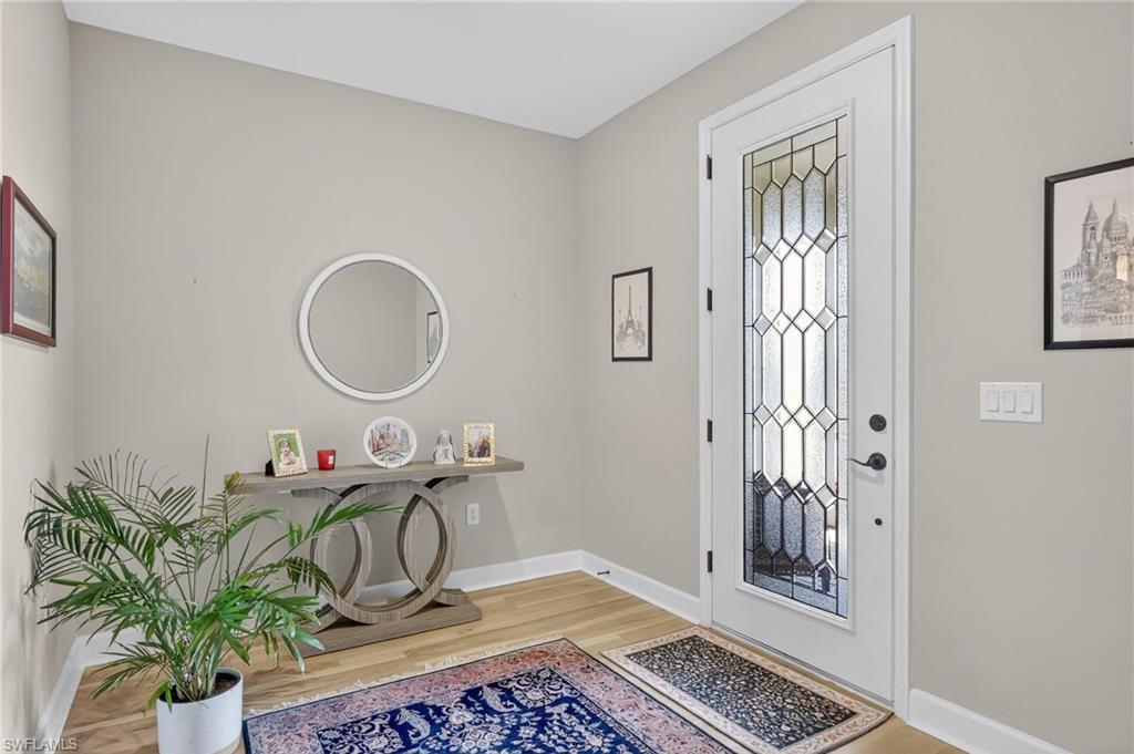 2082 Grove Drive Naples, FL 34120 - Photo 3 of 50 a table with a potted plant and a wooden floor