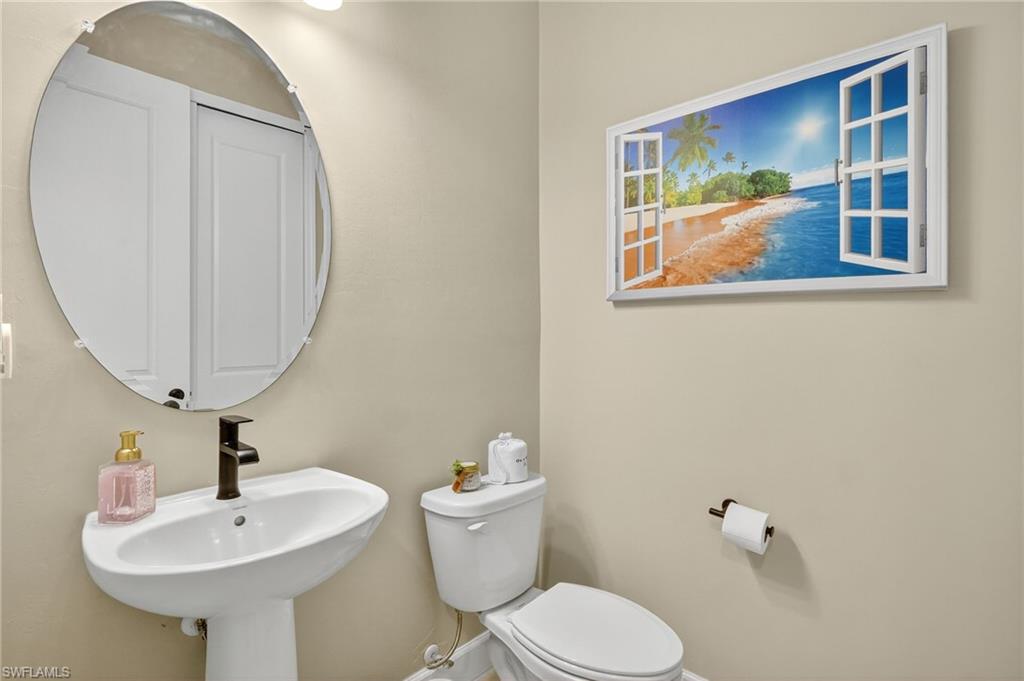 2082 Grove Drive Naples, FL 34120 - Photo 31 of 50 a bathroom with a toilet a sink and a mirror