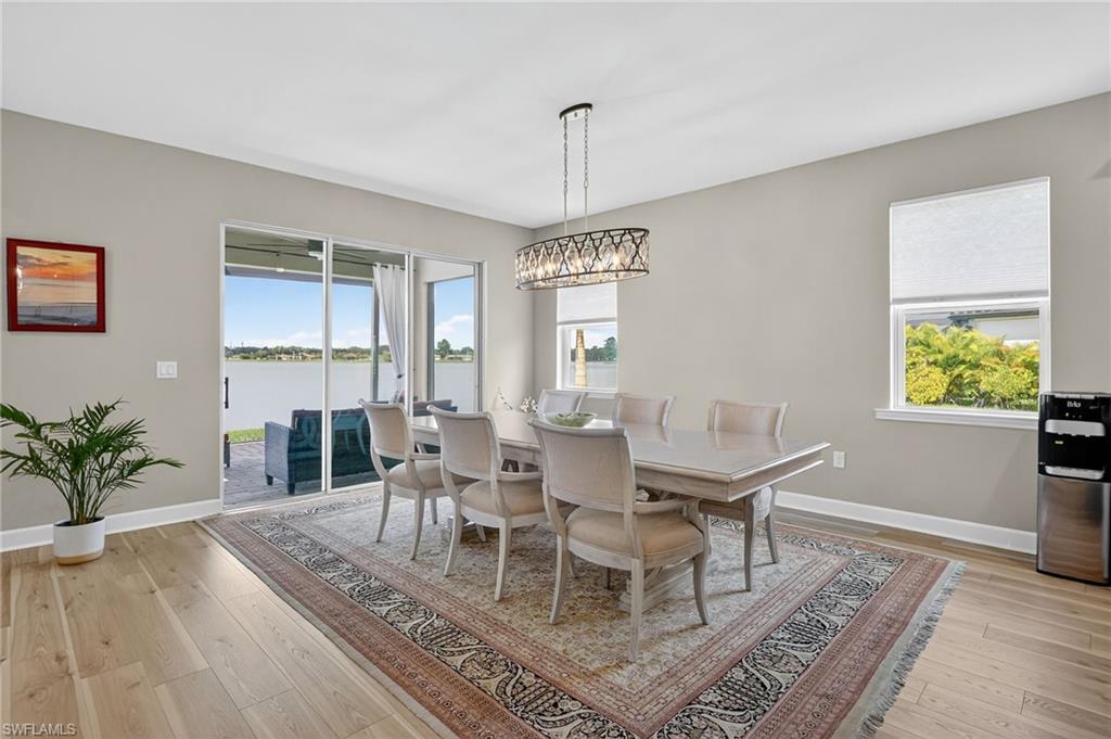 2082 Grove Drive Naples, FL 34120 - Photo 7 of 50 a dining room with wooden floor a chandelier a wooden table and chairs