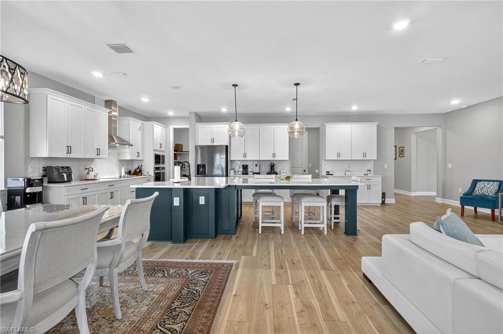 2082 Grove Drive Naples, FL 34120 - Photo 9 of 50 a kitchen with a table chairs microwave and cabinets