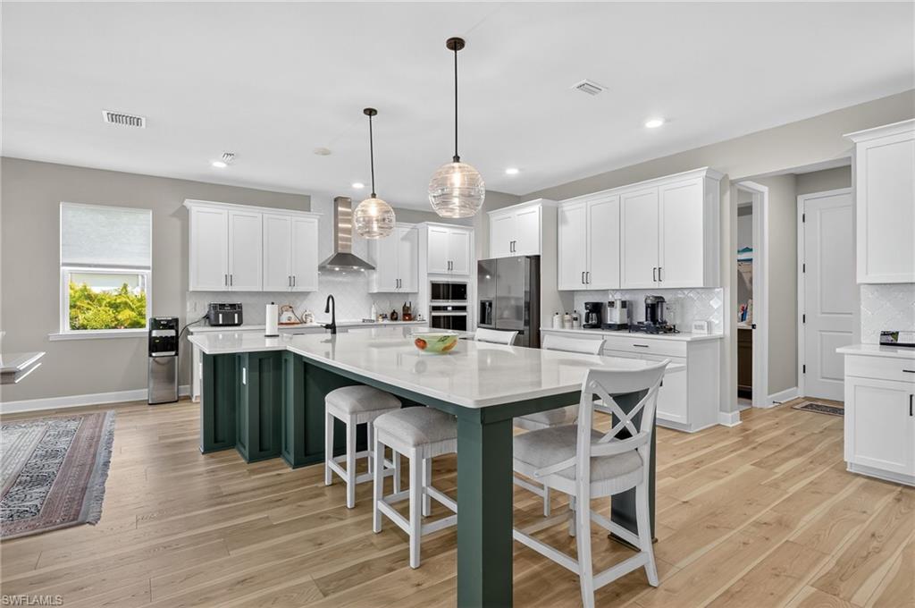 2082 Grove Drive Naples, FL 34120 - Photo 10 of 50 a kitchen with kitchen island granite countertop a sink a center island and stainless steel appliances