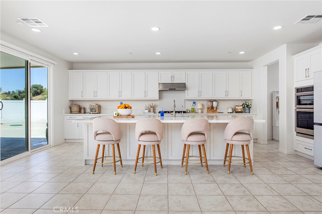 32797 Hayden Road Menifee, CA 92584 - Photo 14 of 51 a kitchen with stainless steel appliances granite countertop a table and chairs in it