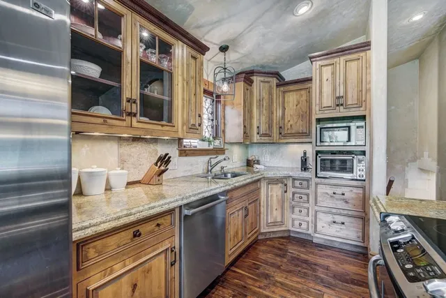 a kitchen with stainless steel appliances granite countertop a stove and cabinets