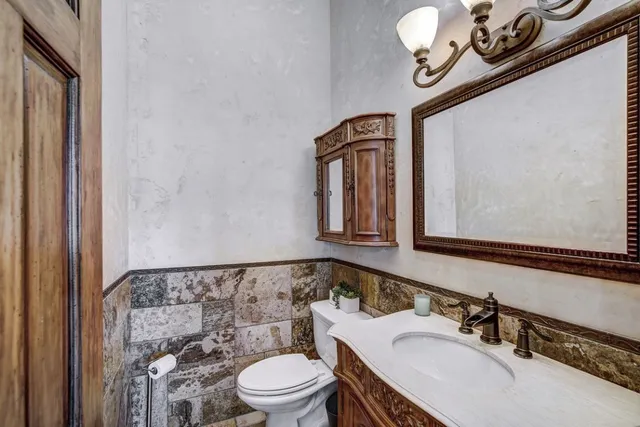 a bathroom with a sink a toilet and mirror