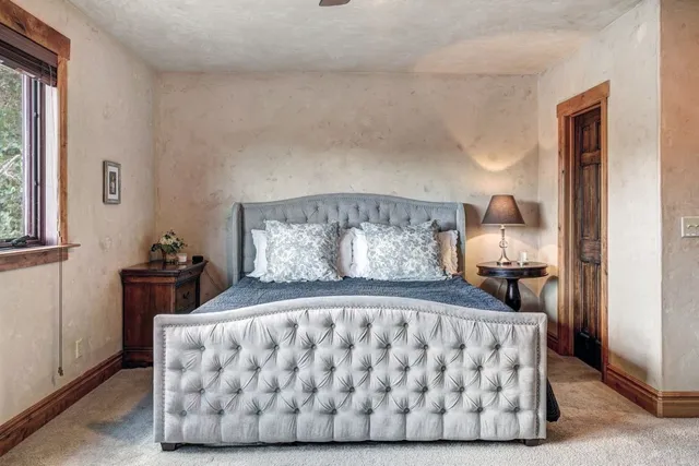 a bed sitting in a bedroom next to a window