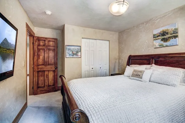 a bedroom with a large bed and a chandelier