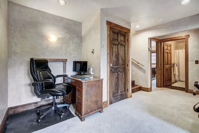 a view of a workspace with furniture and a window
