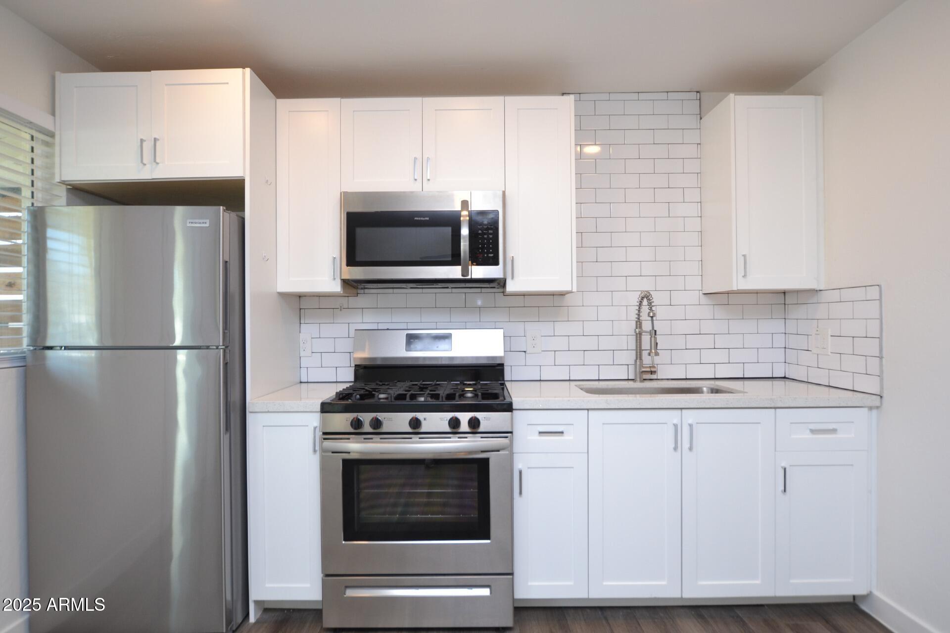 1202 East Kaler Drive, Unit 3 Phoenix, AZ 85020 - Photo 2 of 9 a kitchen with cabinets stainless steel appliances a sink and a counter space