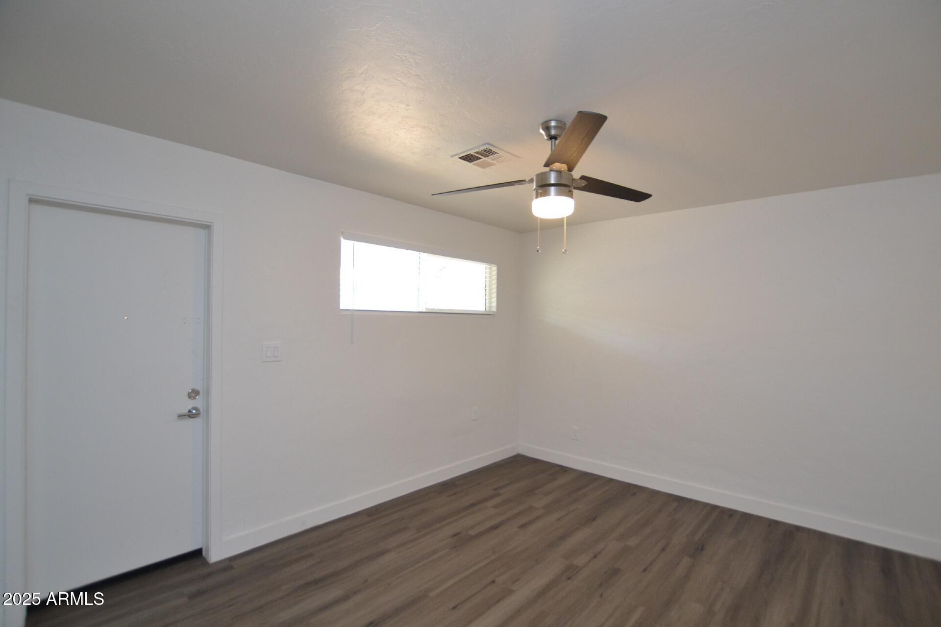 1202 East Kaler Drive, Unit 3 Phoenix, AZ 85020 - Photo 5 of 9 wooden floor in an empty room with a window