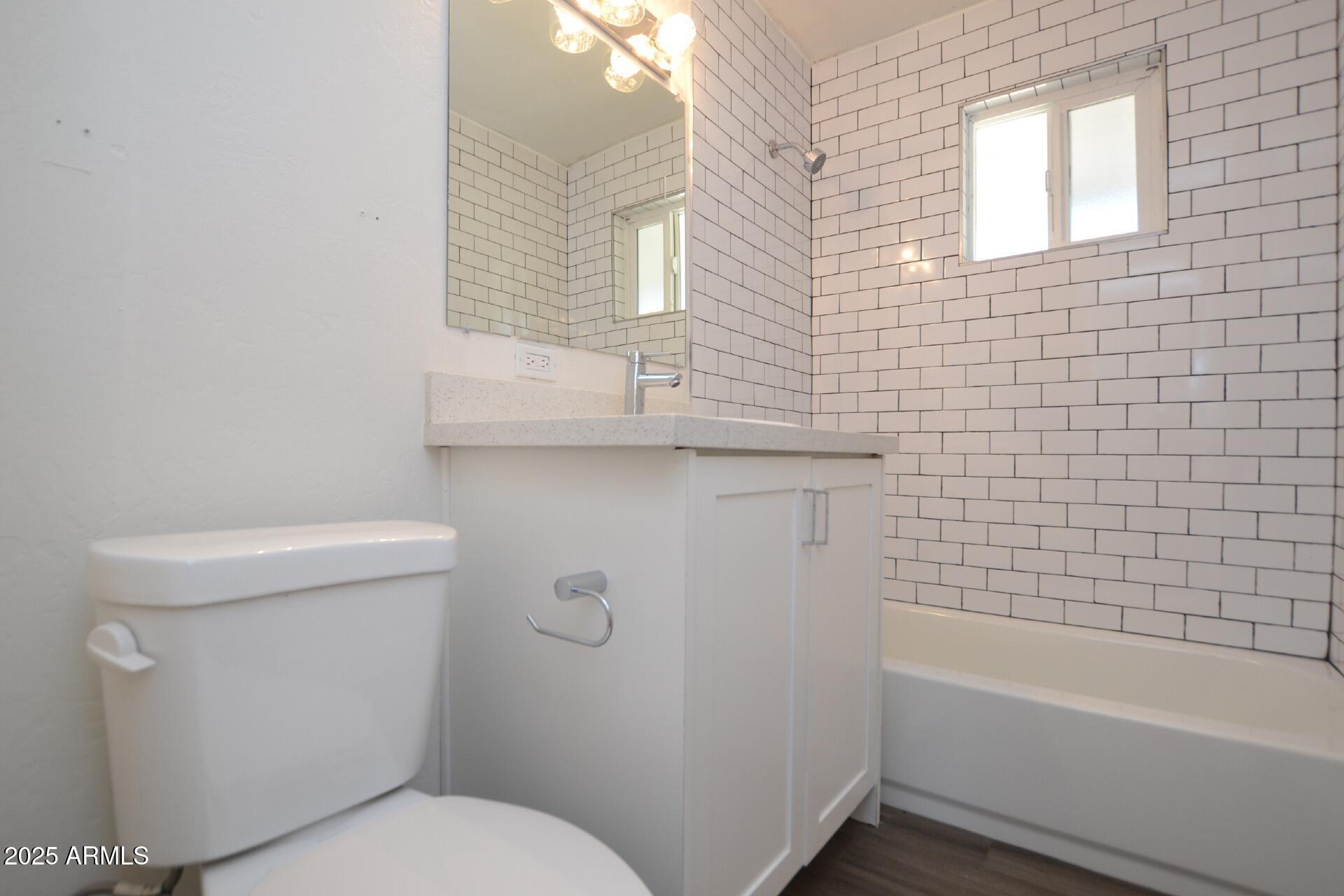 1202 East Kaler Drive, Unit 3 Phoenix, AZ 85020 - Photo 8 of 9 a bathroom with a sink a toilet and bathtub