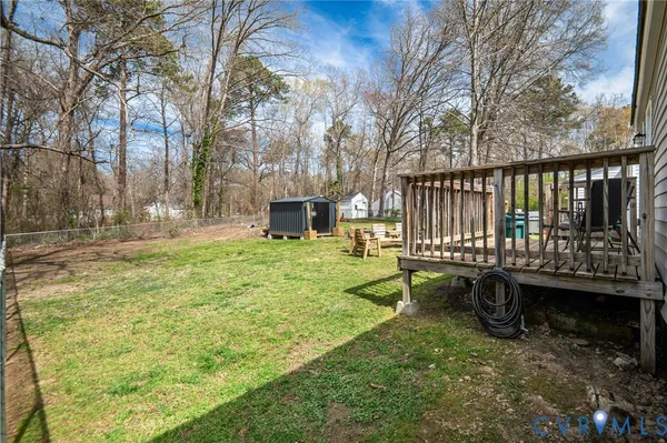 a view of a patio with table and chairs with wooden fence and large trees