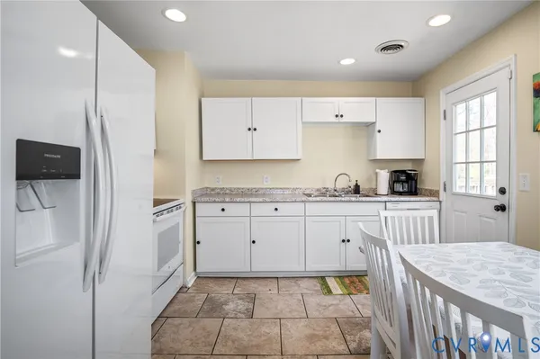 a kitchen with a refrigerator a stove top oven and cabinets