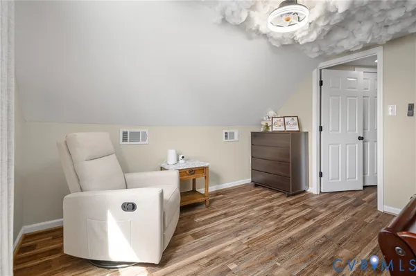 a living room with furniture and a refrigerator