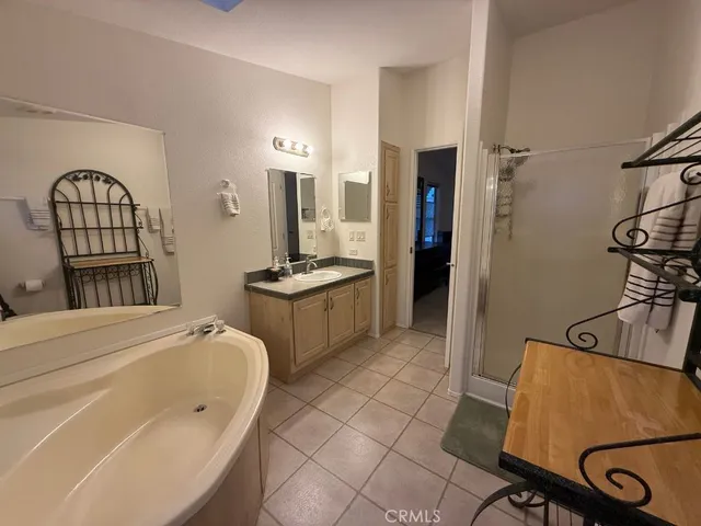 a bathroom with a granite countertop toilet a sink a mirror and shower curtain