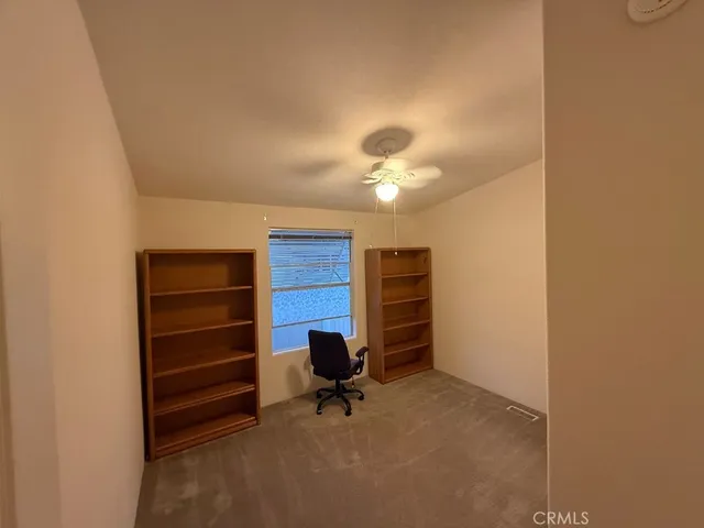 an empty room with chandelier fan